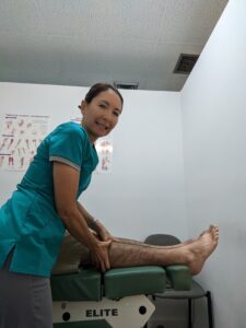 Dr. Natalie Meiri adjusts a patient's knee/leg